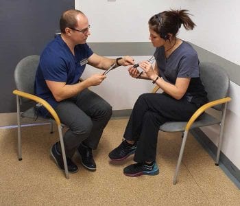 Emma Jones and Ben Harris demonstrating use of a personal hearing loop. Image: Ben Harris.
