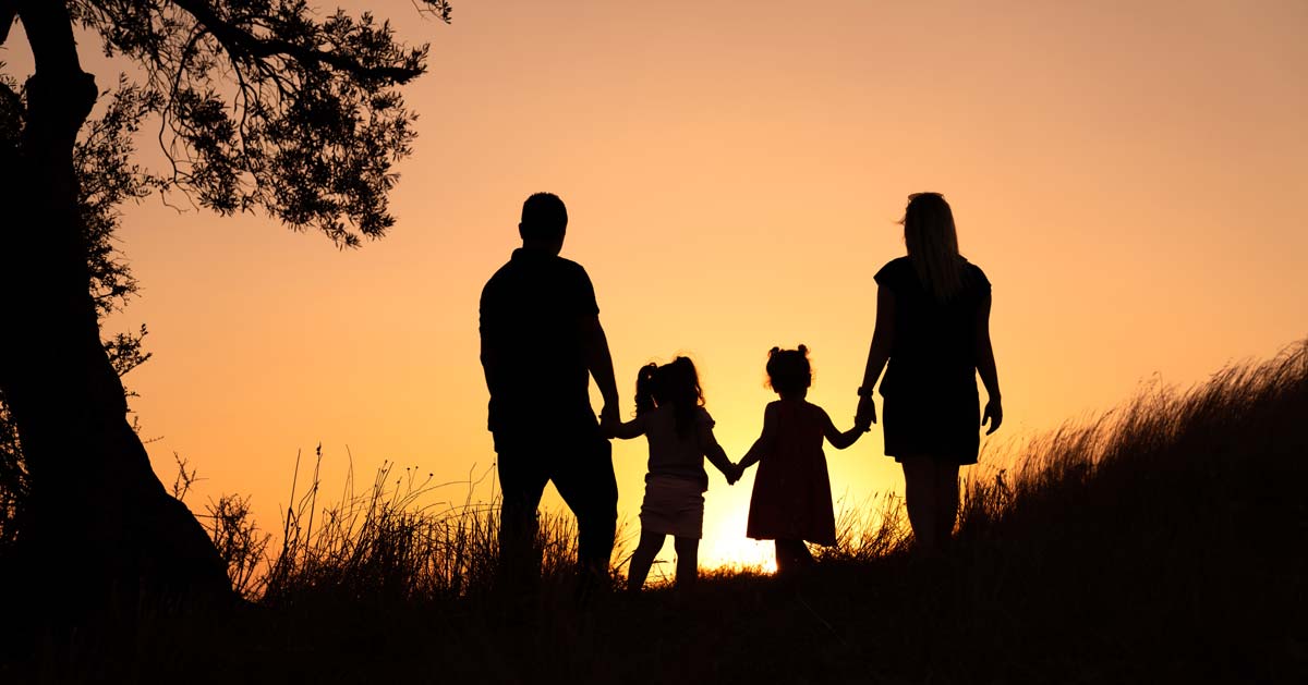 Family silhouette watching sunrise.