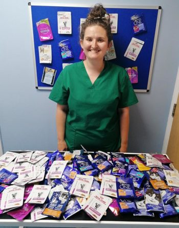 Lucy Rose-Smith with some of the used cat food pouches collected by SimplyCats Vet Clinic.