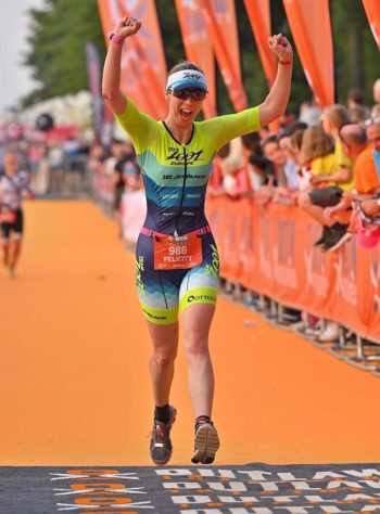 Felicity Caddick crossing the finish line of the ironman triathlon.